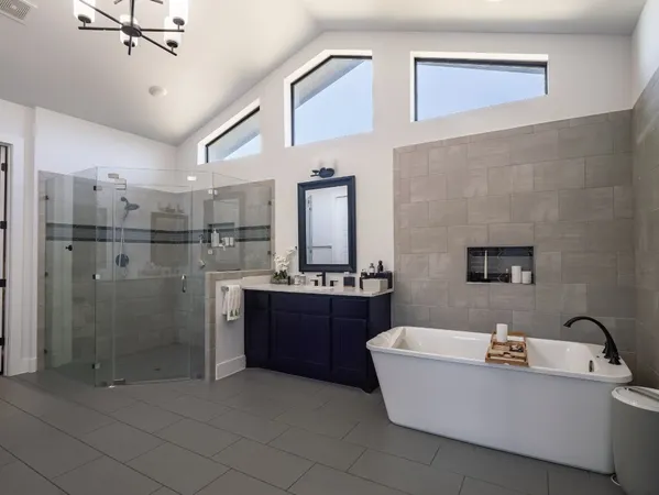 a bathroom with a tub a sink and mirror
