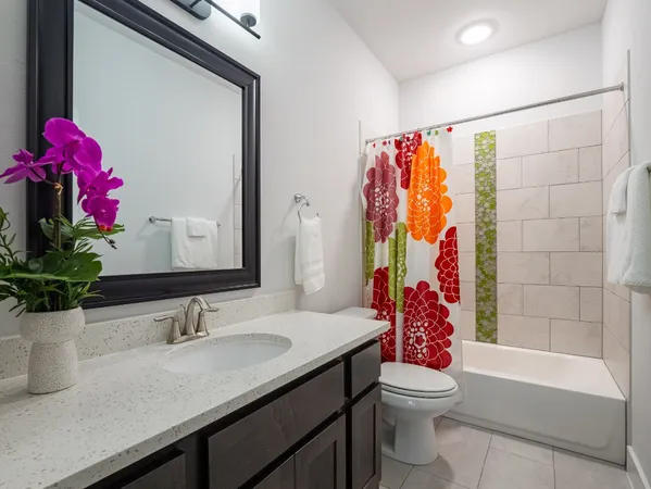 a bathroom with a sink vanity mirror and toilet