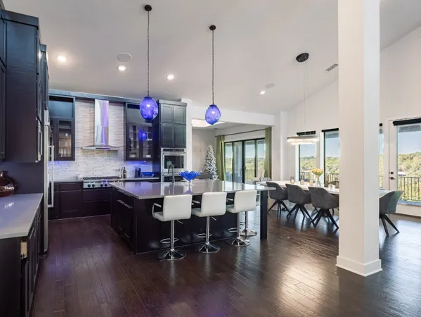 a dining room with wooden floor furniture and a chandelier
