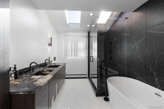 a bathroom with a granite countertop sink a toilet a mirror and bathtub