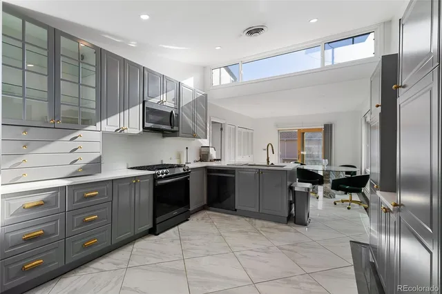 a kitchen with stainless steel appliances granite countertop a sink counter space cabinets and a stove