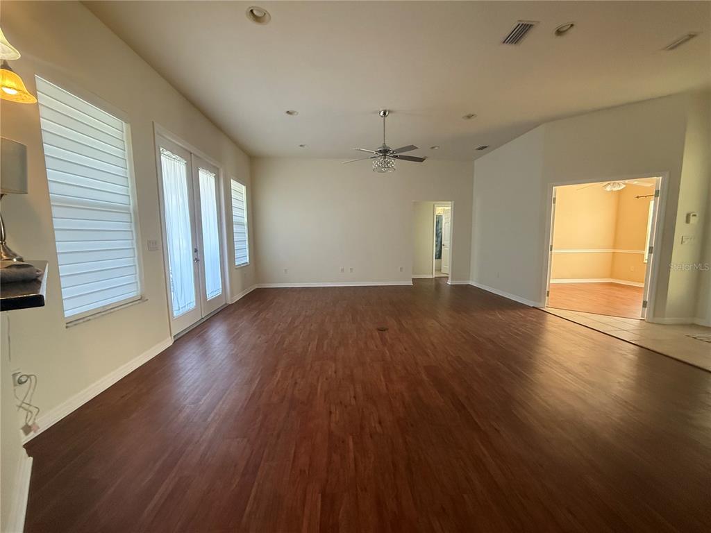 10054 Southwest 98th Avenue Gainesville, FL 32608 - Photo 2 of 14 an empty room with wooden floor and windows
