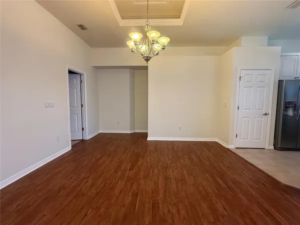 a view of a room with wooden floor and chandelier