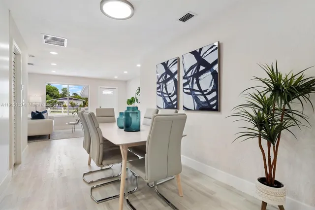 a view of a dining room with furniture and a potted plant