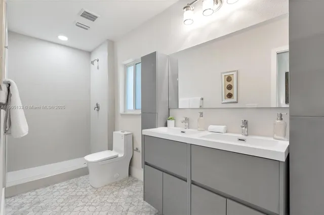 a bathroom with a toilet sink and mirror