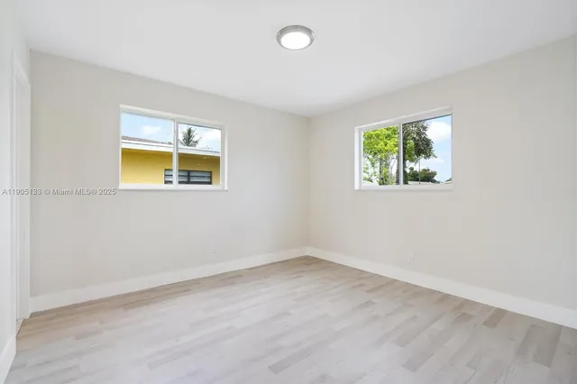 an empty room with windows and closet