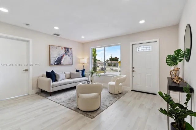 a living room with furniture a potted plant and a table