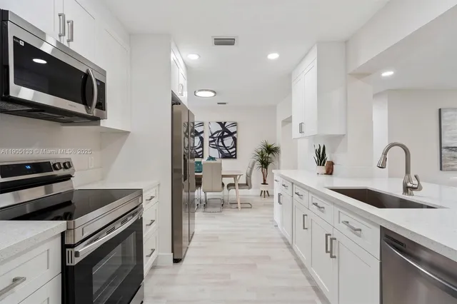 a kitchen with stainless steel appliances granite countertop a sink and a stove top oven