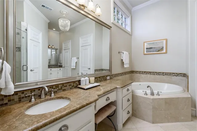 a bathroom with a granite countertop tub sink and mirror