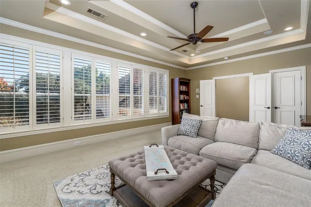 a living room with furniture a ceiling fan and a window