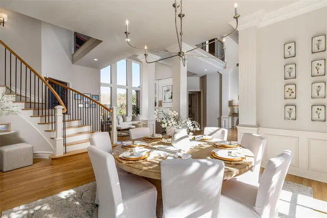 a view of a dining room and livingroom with furniture wooden floor a chandelier