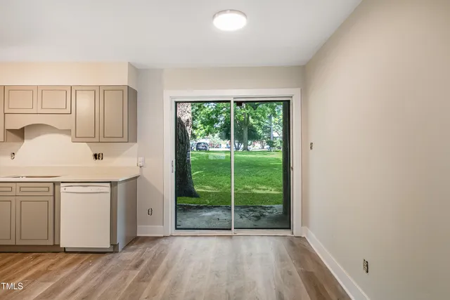 a kitchen with a white cabinets and wooden floor