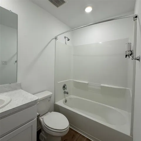 a white toilet and tub sitting next to a bathroom sink
