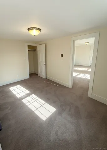 an empty room with windows and chandelier fan