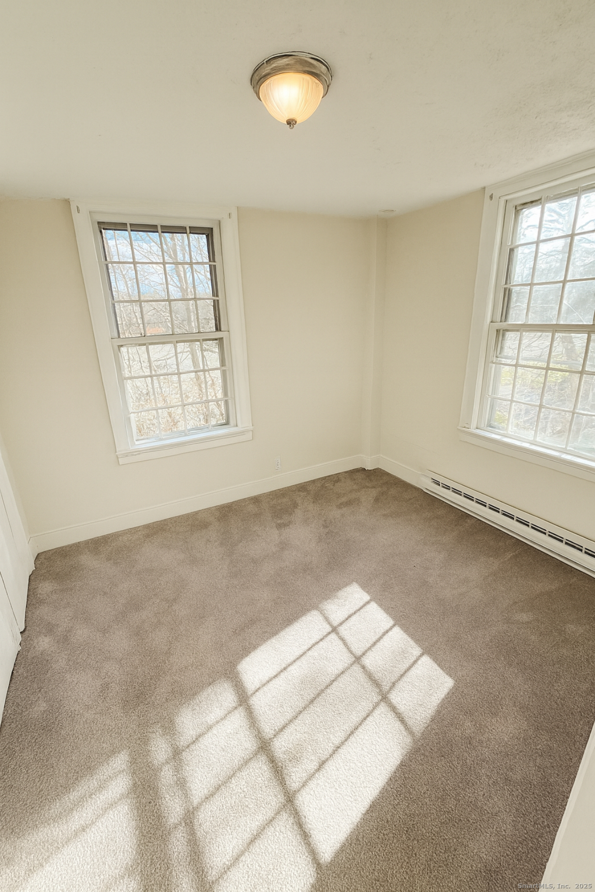 1281 Durham Road Madison, CT 06443 - Photo 19 of 24 an empty room with windows and chandelier fan