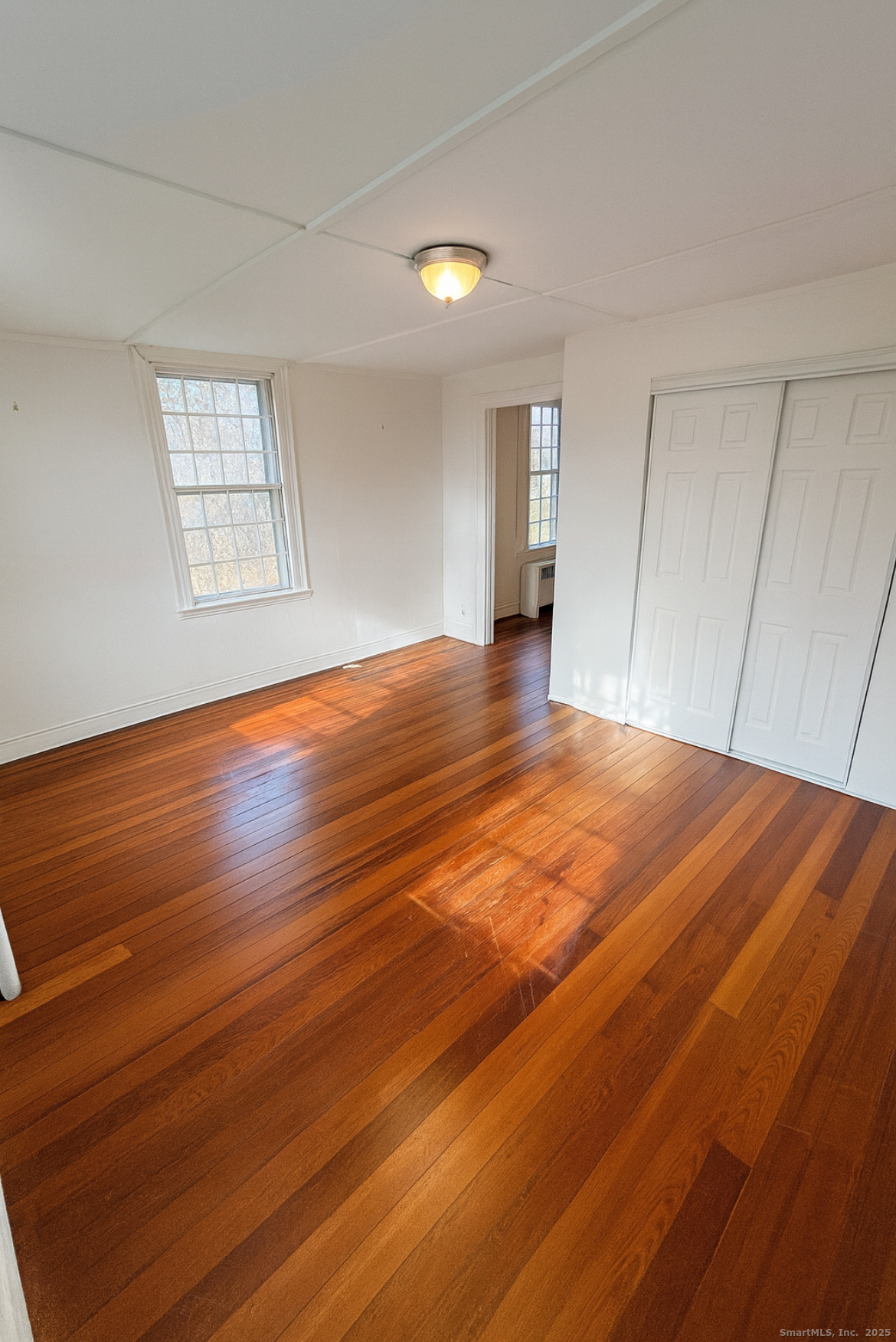 1281 Durham Road Madison, CT 06443 - Photo 7 of 24 a view of an empty room with wooden floor and a window