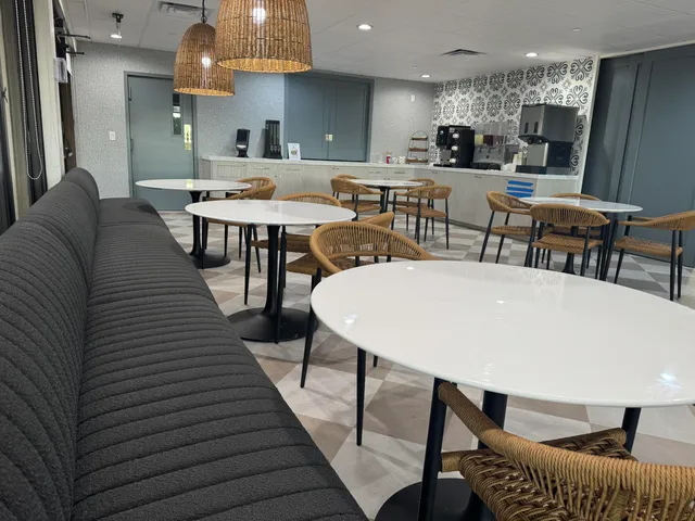 a kitchen with stainless steel appliances kitchen island granite countertop a dining table chairs and a sink