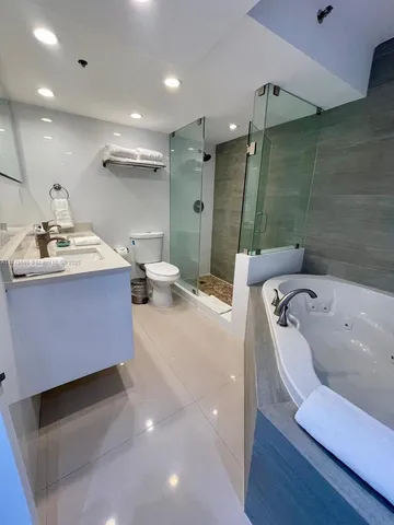 a bathroom with a tub sink and mirror