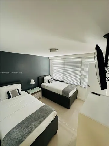 a bedroom with a bed and flat screen tv
