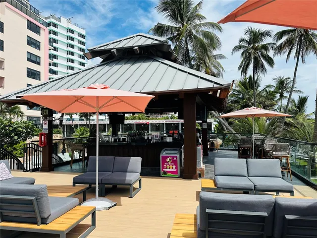 a view of a building with a swimming pool and sitting area