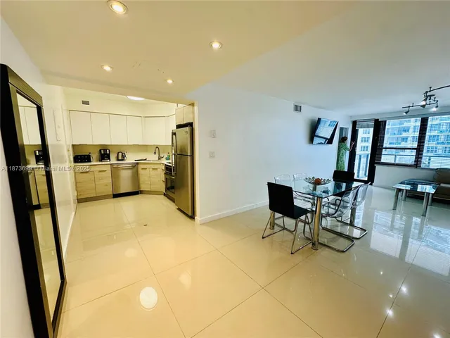 a view of a kitchen with furniture and a refrigerator