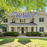 a front view of a house with a yard and potted plants