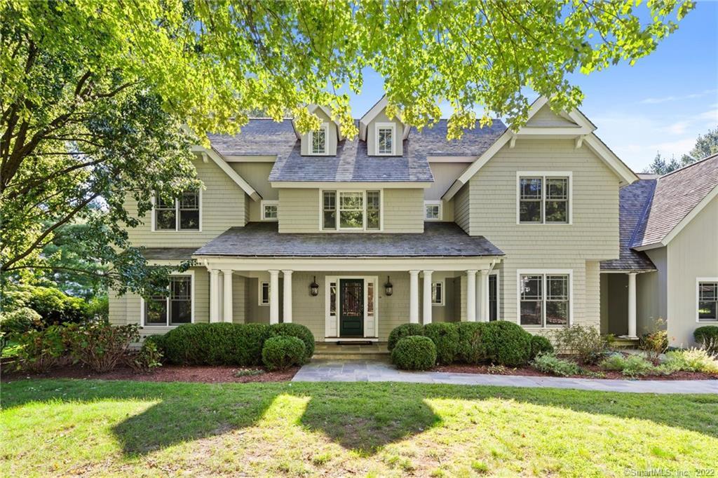 a front view of a house with a yard and potted plants