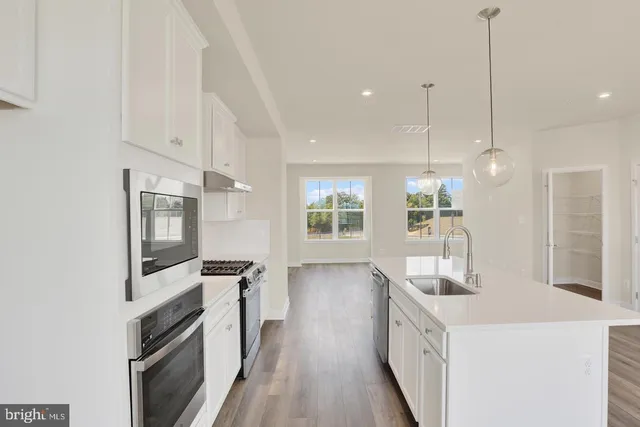 a kitchen with stainless steel appliances a refrigerator and wooden floor