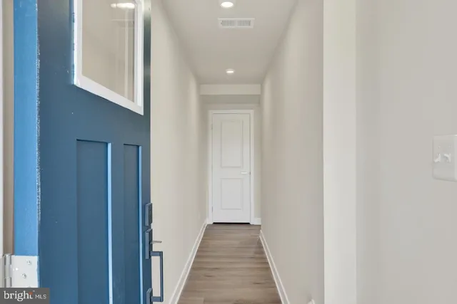 a view of a hallway with wooden floor