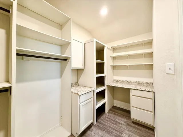 a room with walk in closet and wooden floor