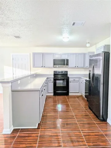 a large kitchen with cabinets and stainless steel appliances