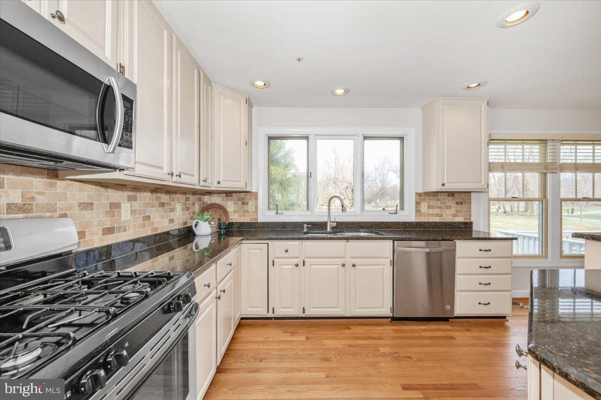 17900 Hickman Street Poolesville, MD 20837 - Photo 17 of 97 a kitchen with stainless steel appliances granite countertop a stove a sink and a microwave