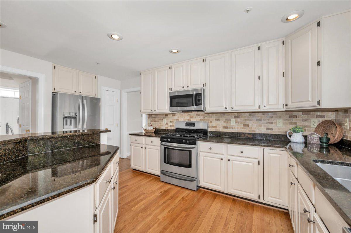 17900 Hickman Street Poolesville, MD 20837 - Photo 20 of 97 a large kitchen with granite countertop a stove top oven a sink a counter space and cabinets