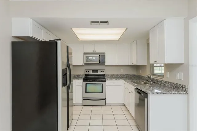 a kitchen with a refrigerator and a stove top oven