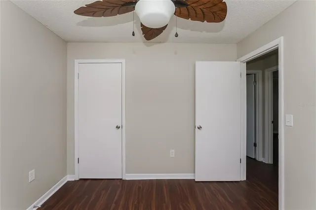 an empty room with wooden floor and cabinets