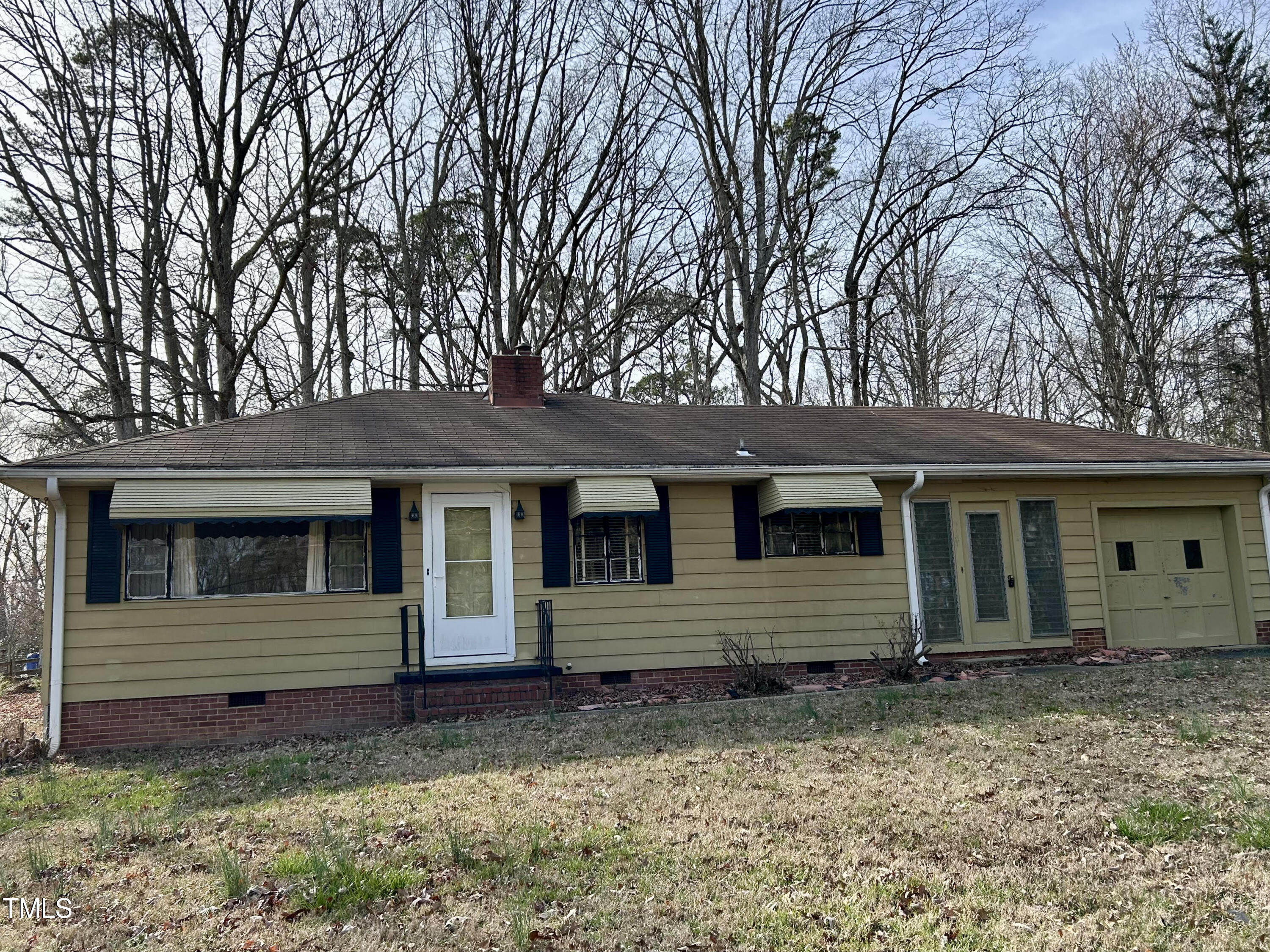 a view of house with a backyard