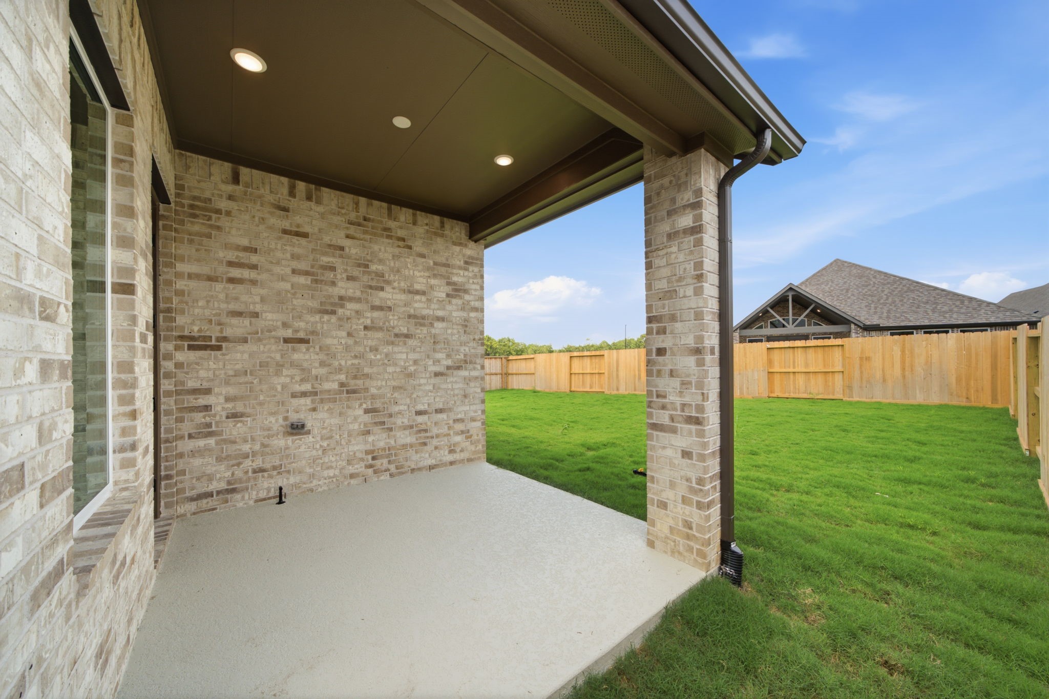 21956 Rolling Grns Road Porter, TX 77365 - Photo 35 of 43 Covered rear patio with recessed lighting overlooks the fenced backyard, creating an inviting space for outdoor relaxation and entertaining.