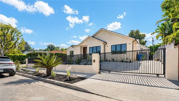 a view of a house with a wooden fence