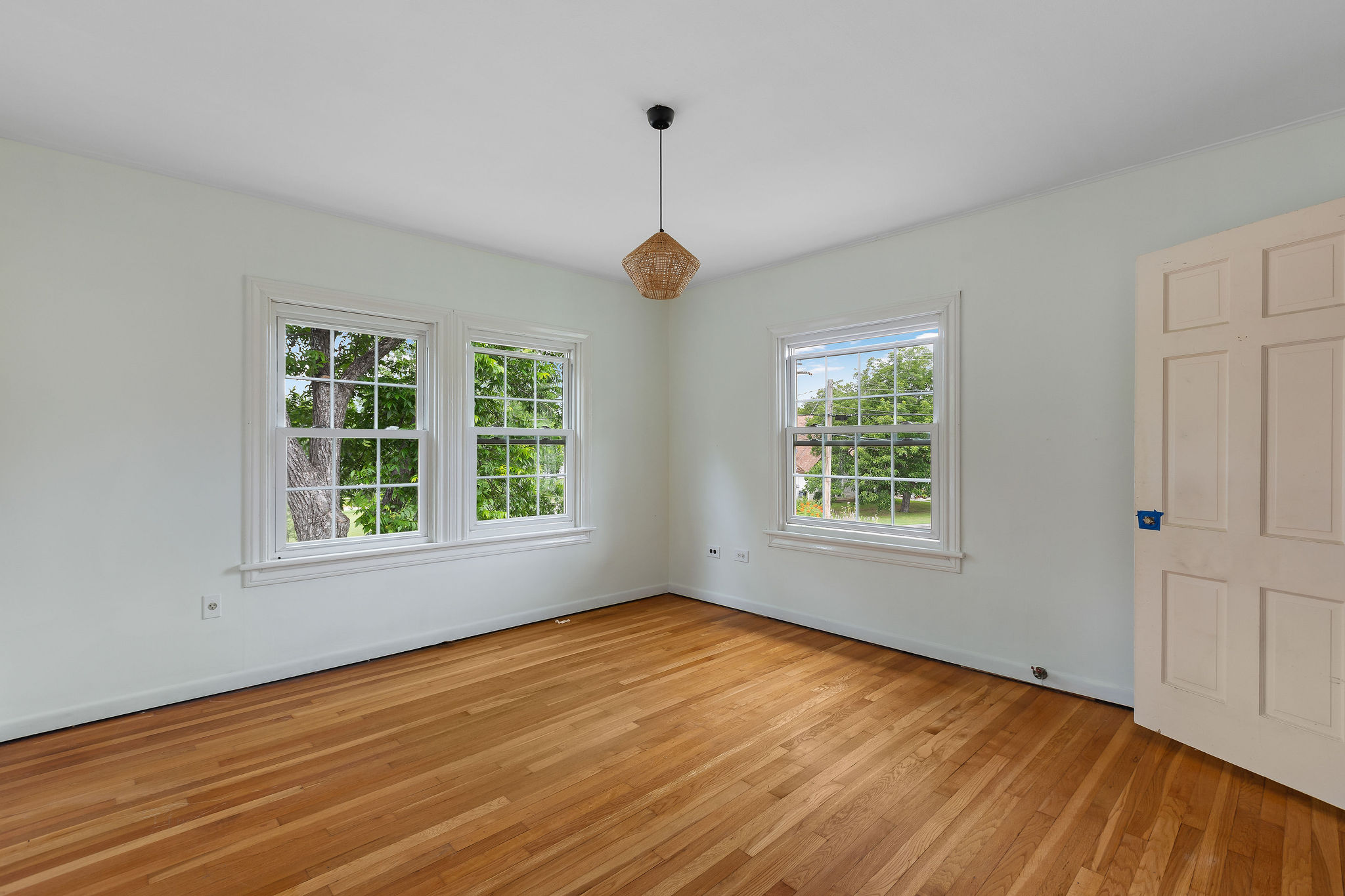 948 Maple Street Lockhart, TX 78644 - Photo 29 of 40 Hardwood flooring extends throughout this light-filled room, enhanced by multiple windows framing outdoor greenery.