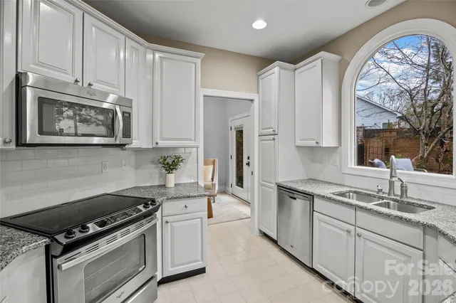a kitchen with stainless steel appliances granite countertop a refrigerator and a stove