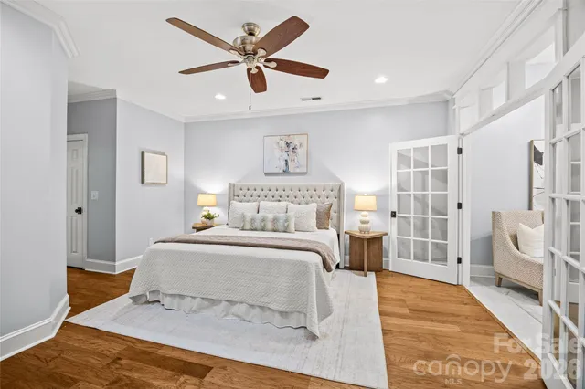 a bedroom with a large bed and a chandelier