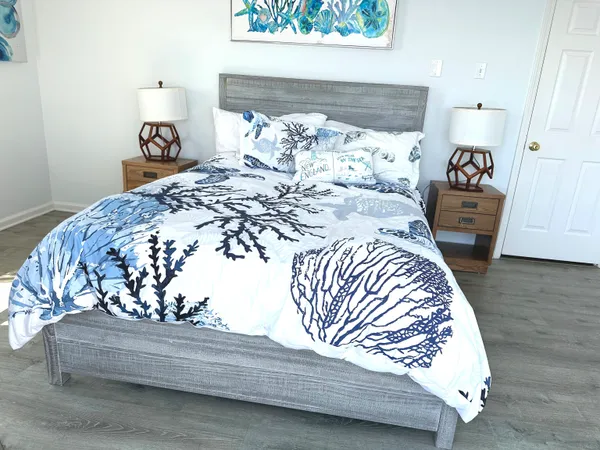 a bedroom with a bed a flat screen tv and next to a window