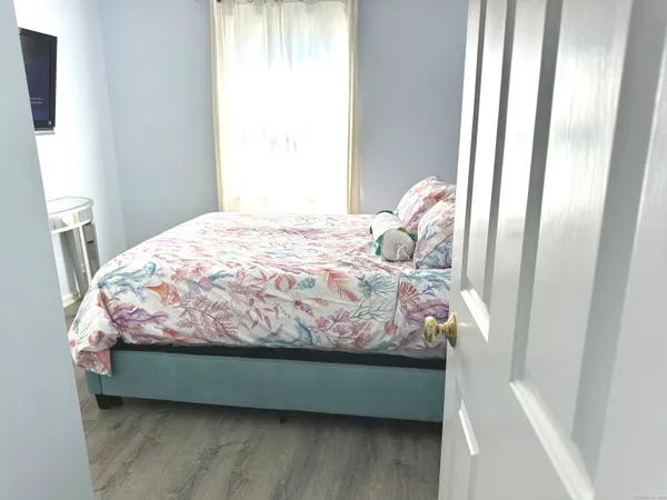 a bedroom with a bed and a flat screen tv