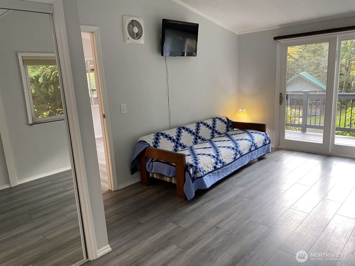 111 North Jorstad Creek Road Lilliwaup, WA 98555 - Photo 5 of 23 a bedroom with a bed window and wooden floor