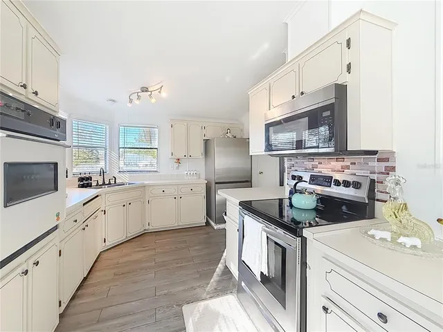 a kitchen with a refrigerator a stove and a window