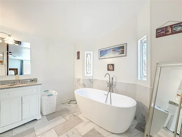 a living room with furniture a wooden floor and a potted plant