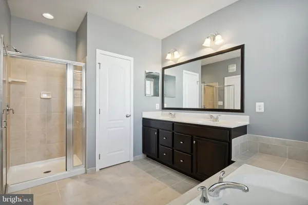 a bathroom with a double vanity sink mirror and shower