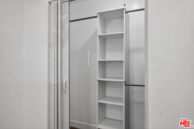 a view of walk in closet with empty racks