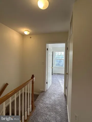 a view of hallway with hardwood floor and a window