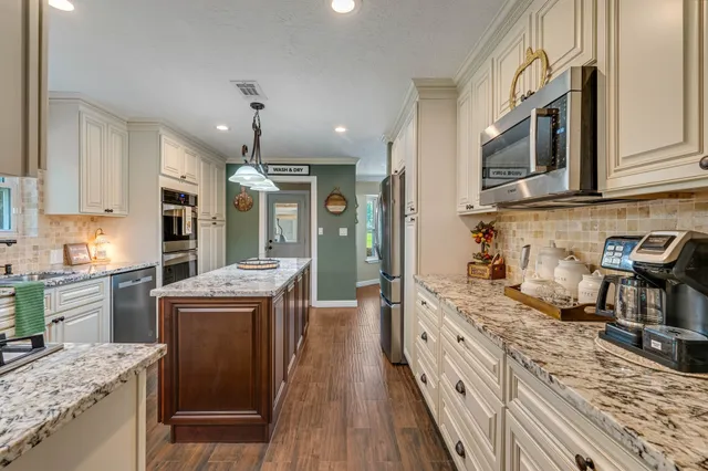 a kitchen with stainless steel appliances granite countertop a sink stove and refrigerator